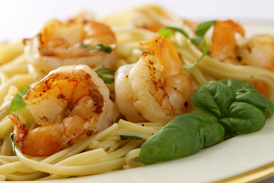 Jumbo shrimp scampi and linguini with basil on white plate